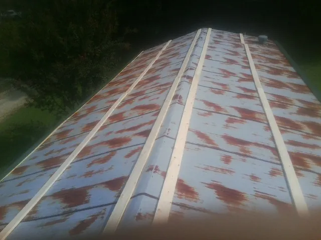 Rusted metal roof panels with new wood purlins before replacement — Storm Damage Roof Repair in Pflugerville by Roofing Brothers