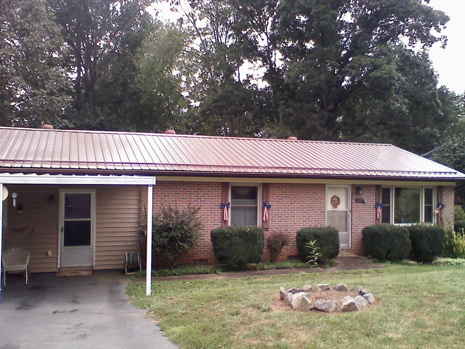 Bronze metal roof and carport on a brick ranch home — Roof Repair work by our crew in Pflugerville