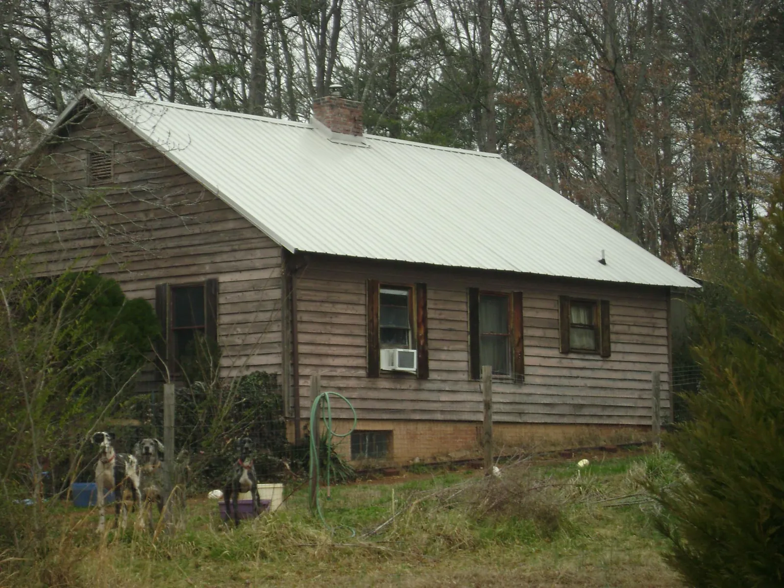 White metal roof on an old wood sided farmhouse, from a Metal Roof Installation job in Pflugerville